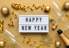 flat-lay-happy-new-year-message-with-golden-decorations-golden-ribbons-confetti-and-champagne-...jpg